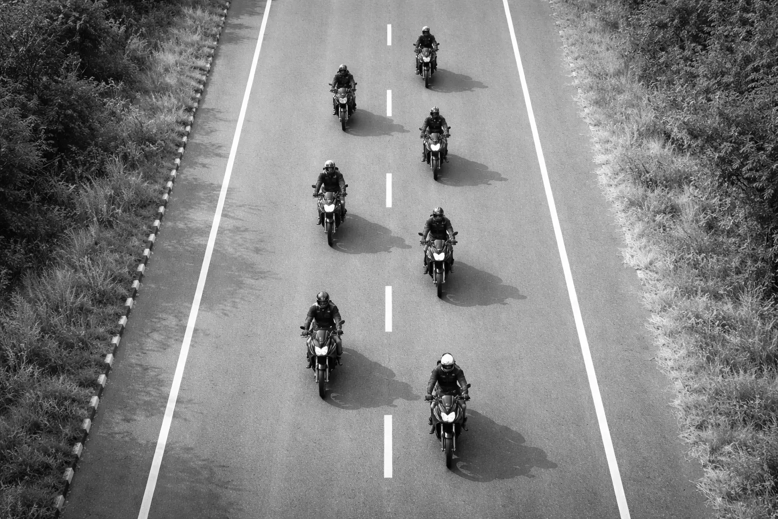 Group of riders moving together in a staggered formation on a highway